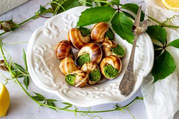 Bourguignonne snail with lemon. Marble background. French cuisine.