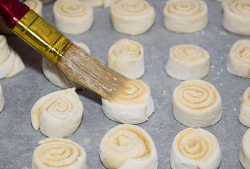 Spirals of sweet rolls rest on a cookie sheet