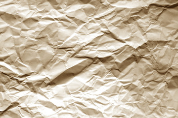 Crumpled sheet of paper with blur effect in brown tone.