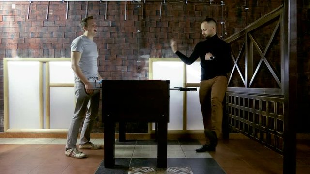 Sport, game concept. Foosball. Two men playing a table football or kicker with miniature players. 4K