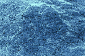 Vintage blue background. Rough painted wall of sapphire color. Imperfect plane of blue colored. Uneven old decorative toned backdrop of cyan tint. Texture of sapphirine hue. Ornamental stony surface.
