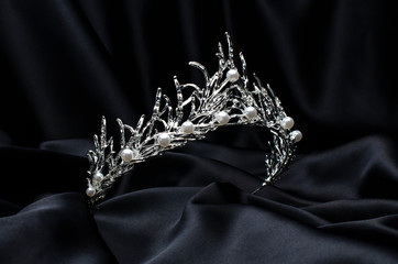 tiara with pearls isolated on a black silk © vitaly tiagunov