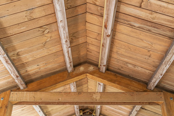 background of wooden vaulted ceiling with bearing beams and rafters close up