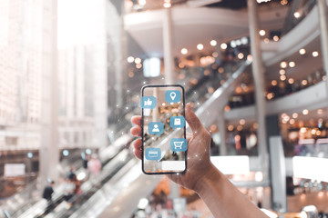 Women in shopping mall using mobile phone with shopping application and social media. 