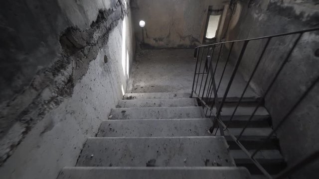 Climbing spooky stairs in darkness. Going up dark and dangerous stairs in creepy stairwell alone. slow motion. Explosion