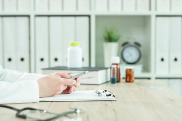 Doctor using smartphone in medical office