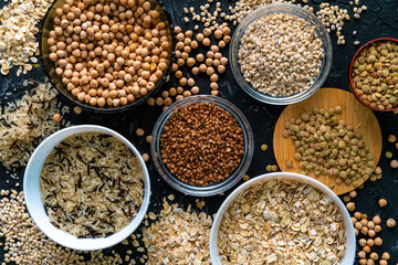 selection of raw uncooked cereals grains  in bulbs with chickpeas oat lentil rice buckwheats