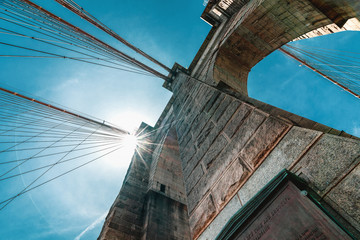 Fototapeta premium Brooklyn Bridge, New York City. Architectural Close up Detail, An Iconic Steel Cables against Bright Sun and Blue Sky