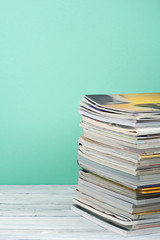 Open stacking book, magazine hardback colorful books on wooden table and green background. Back to school. Copy space for text. Education business concept.