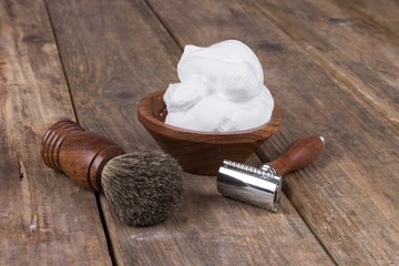  vintage shaving accessories  - wooden razor with shaving brush and shaving foam on a rustic wooden table
