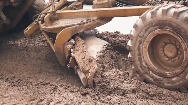 Under construction with Motor grader or soil road grade plowing soil ground for built site conQstruction. It is construction machine.