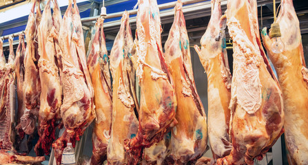 Meat concept. Lamb, sheep hanged on hooks, butcher shop. Uncooked mutton for background, closeup.