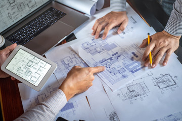 Construction engineering discussing a blueprint while checking information