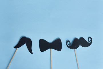 Black mustaches on blue paper background. Happy fathers day greeting card and place for text. Hipsters objects flat lay