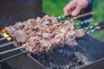 meat on skewers roasted over the coals.picnic in nature. preparation of a shish kebab.