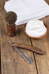 Fototapeta na wymiar shaving accessories - wooden razor with shaving brush and shaving foam on a rustic wooden table