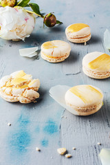 Draufsicht von macarons und von weißen Pfingstrosenblumen auf Holzoberfläche