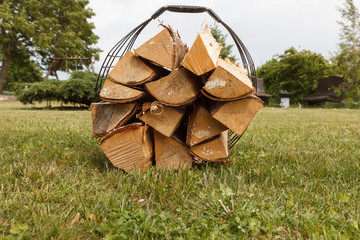 basket with firewood in green grass ready for picnic