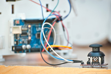 Electronics and robotics of handmade. Microcircuits and colored wires close up. Electronic devices and mechanisms are presented at the scientific exhibition. Joystick and control button.
