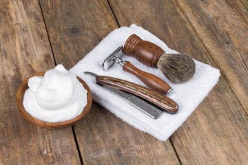 vintage shaving accessories  - wooden razor with shaving brush and shaving foam on a rustic wooden table