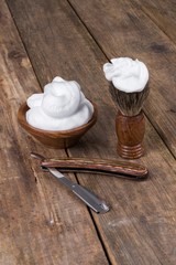 vintage shaving accessories  - wooden razor with shaving brush and shaving foam on a rustic wooden table