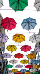 Fototapeta na wymiar colorful street art umbrellas in dublin hanging in pattern above street in temple bar destrict - symbol for joy and fun