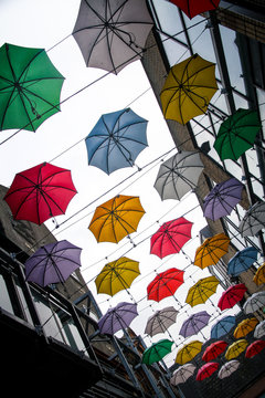 colorful street art umbrellas in dublin hanging in pattern above street in temple bar destrict - symbol for joy and fun - different perspektive