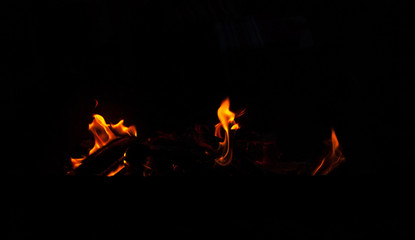 Fire flame isolated on black background. Real tongues of flame background from the fireplace