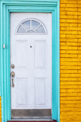 White Door with Turquoise Trim on Orange Brick Building