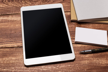 Office workplace with text space,  wooden table with office supplies tablet, desktop computer and book, top view