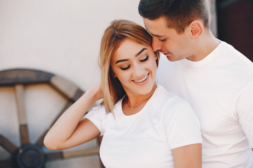 Fototapeta premium Cute couple in a park. Lady in a white t-shirt. 