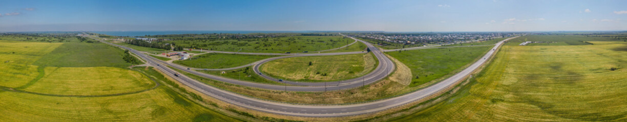Aerial panoramic view of transportation highway overpass, ringway, roundabout, urban traffic
