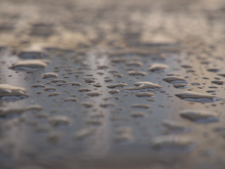 Close up of water droplets on grey car.