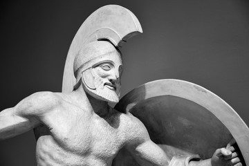 Ancient statue of warrior in helmet with shield.  Historic sample of ancient male beauty. God of war heroic