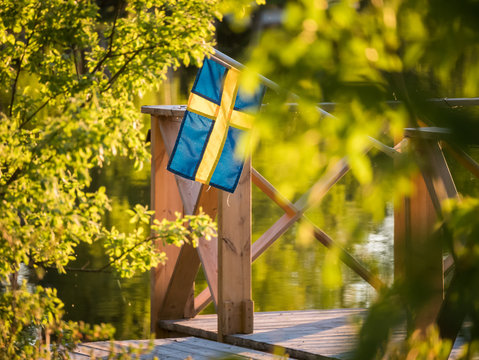 Swedish Flag On A Floating Dock In Summer Sunset Light In Sweden.