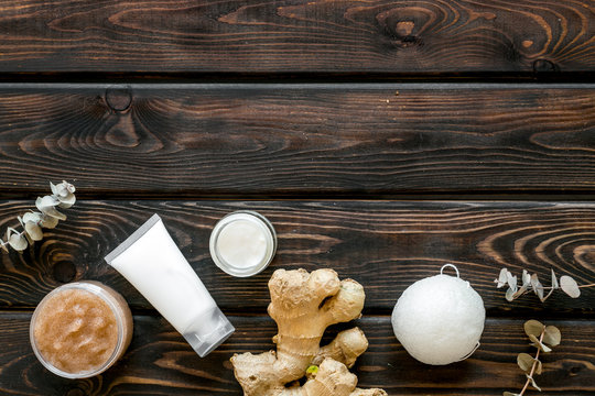 Scrabs and creams for natural cosmetic set with herbs and ginger on wooden background top view mock-up