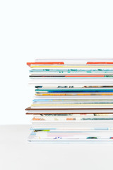 Close view of Stack of children's books on a pastel blue background.
