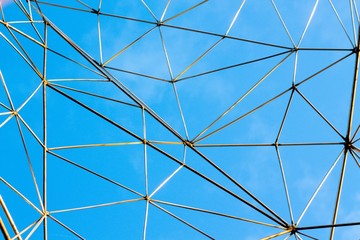 Obraz premium Large metal mesh on a background of clean blue sky. The net is made to catch the clouds.