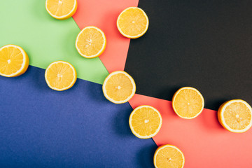 Top view of juicy and fresh cut lemons on multicolored background