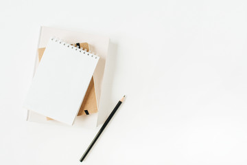 Minimalist office desk workspace with notebook on white background. Flat lay, top view.