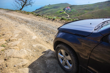 Fototapeta na wymiar Off-road Car Moves along a dirt mountain road
