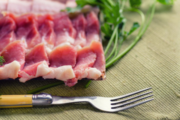 Raw chopped bacon for cooking. Fresh cooked food. Fresh cold sliced bacon on the background of natural linen fabric.  Bacon slices close-up.
