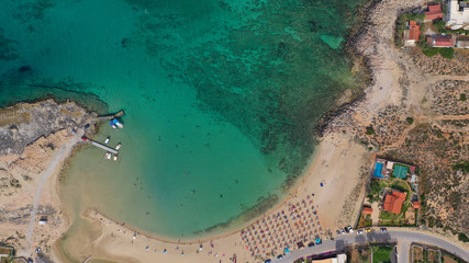 Aerial drone top view photo of turquoise organised beach forming a small heart shaped lagoon and mountainous seascape of Stavros, Chania, Crete island, Greece