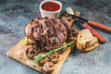 Baked lamb with mushrooms, spices and herbs on a concrete background. Halal meat and food