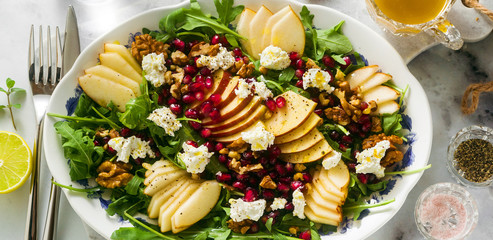 Fototapeta na wymiar banner of Pomegranate & Pear Green Salad with Ginger Dressing on white marble . healthy breakfast or lunch