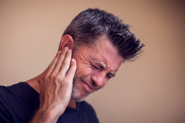 Fototapeta premium Man feels ear pain isolated. People, healthcare and medicine concept