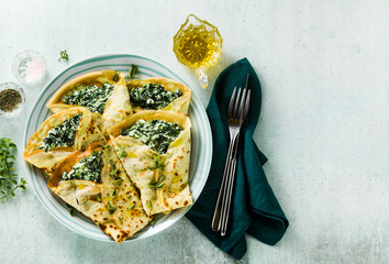 Traditional Italian pancakes crepes with spinach and ricotta on a served table. healthy vegetarian diet