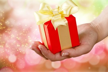 Human hand holding Little christmas box with bow isolated on white background