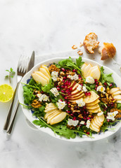 Pomegranate & Pear Green Salad with Ginger Dressing on white marble . healthy breakfast or lunch