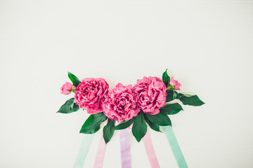 Layout with peony flowers composition with pastel colors ribbons on a white background. Love, Wedding. Festive Floral mockup. Greeting card. Flat lay, top view. Vintage, retro toning. Copy space.